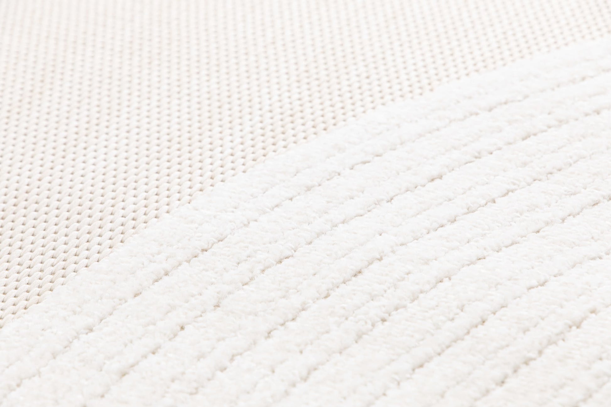 Tapis beige et crème avec deux types de tissage. Relief en lignes et texture tactile douce. Ambiance cocooning