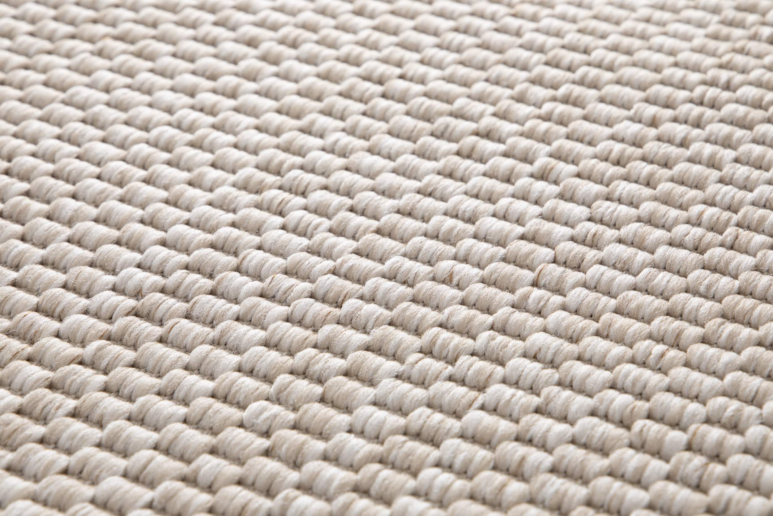 Tapis beige, tissage serré, relief texturé en diagonale, aspect tactile et doux