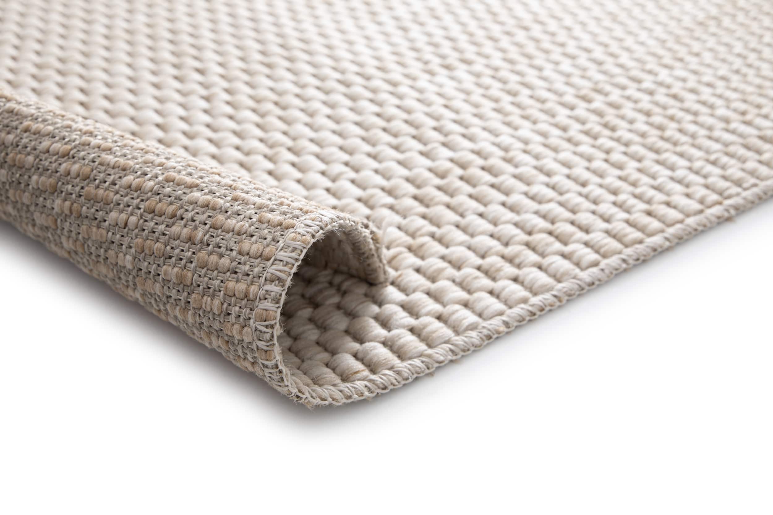 Tapis beige tissé, texture dense et moelleuse. Confort apparent, ambiance chaleureuse. Forme rectangulaire
