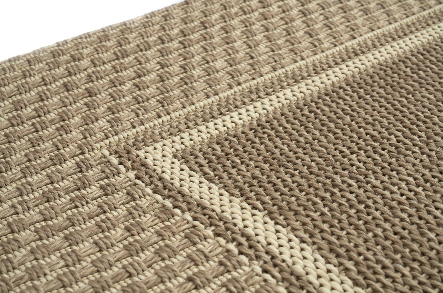 Tapis rectangulaire tissé, relief texturé. Tissage en chevrons et mailles, couleurs beige et sable. Aspect tactile