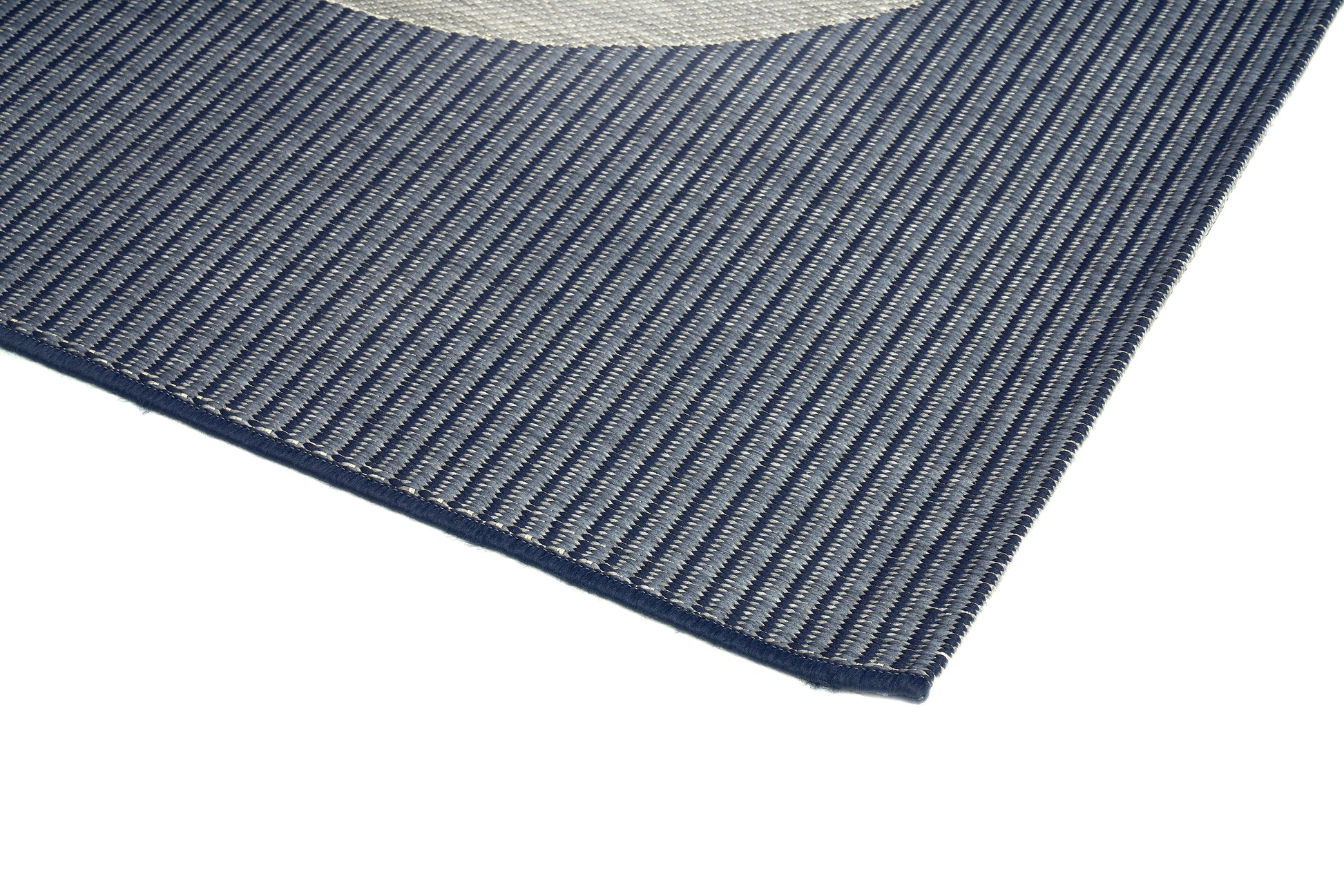 Tapis rectangulaire tissé à rayures diagonales. Tissage plat avec relief subtil. Aspect tactile et couleurs gris et bleu