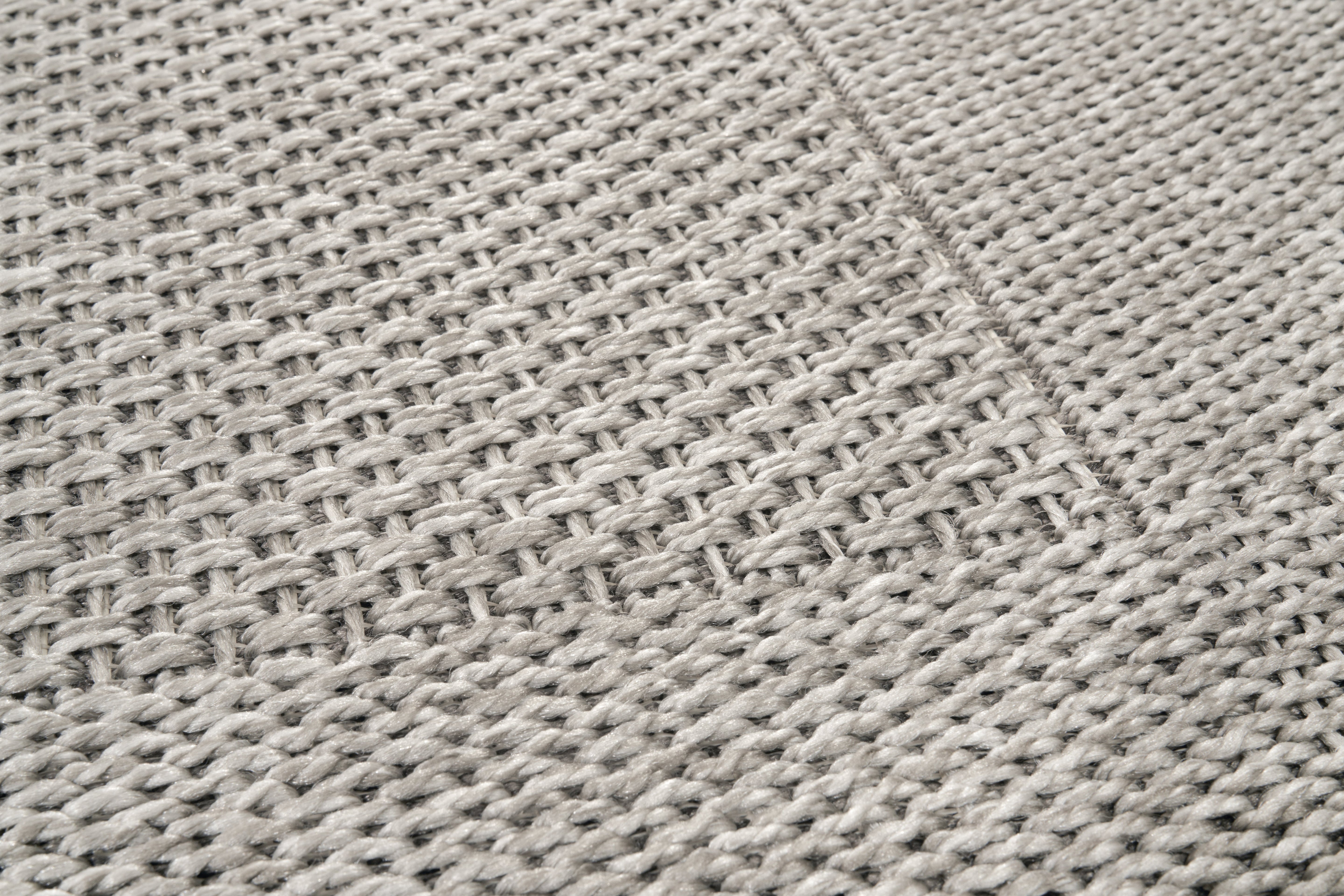 Tapis rectangulaire tissé en relief, texture tactile. Tissage en chevrons, couleurs gris et perle. Ambiance sobre