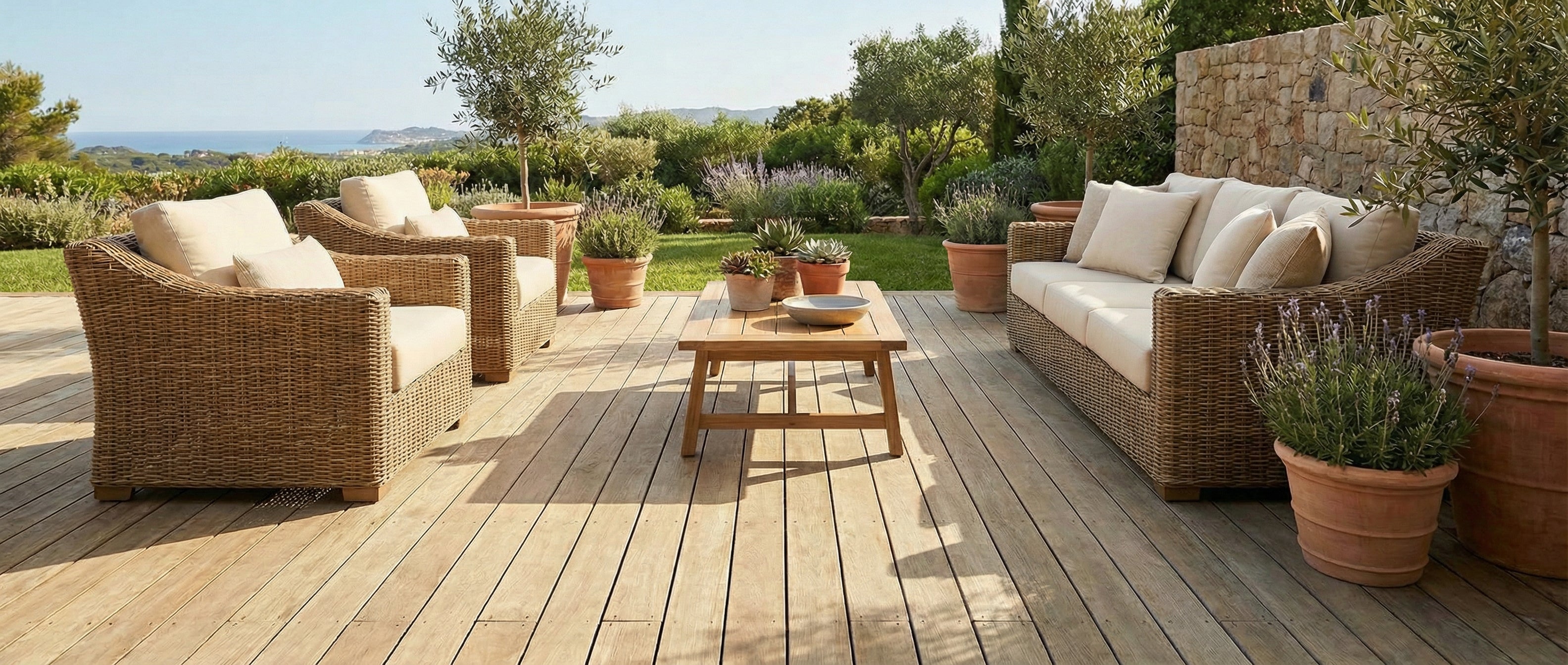 Terrasse en bois avec mobilier taupe, espace vide pour un tapis rectangulaire, ambiance ensoleillée
