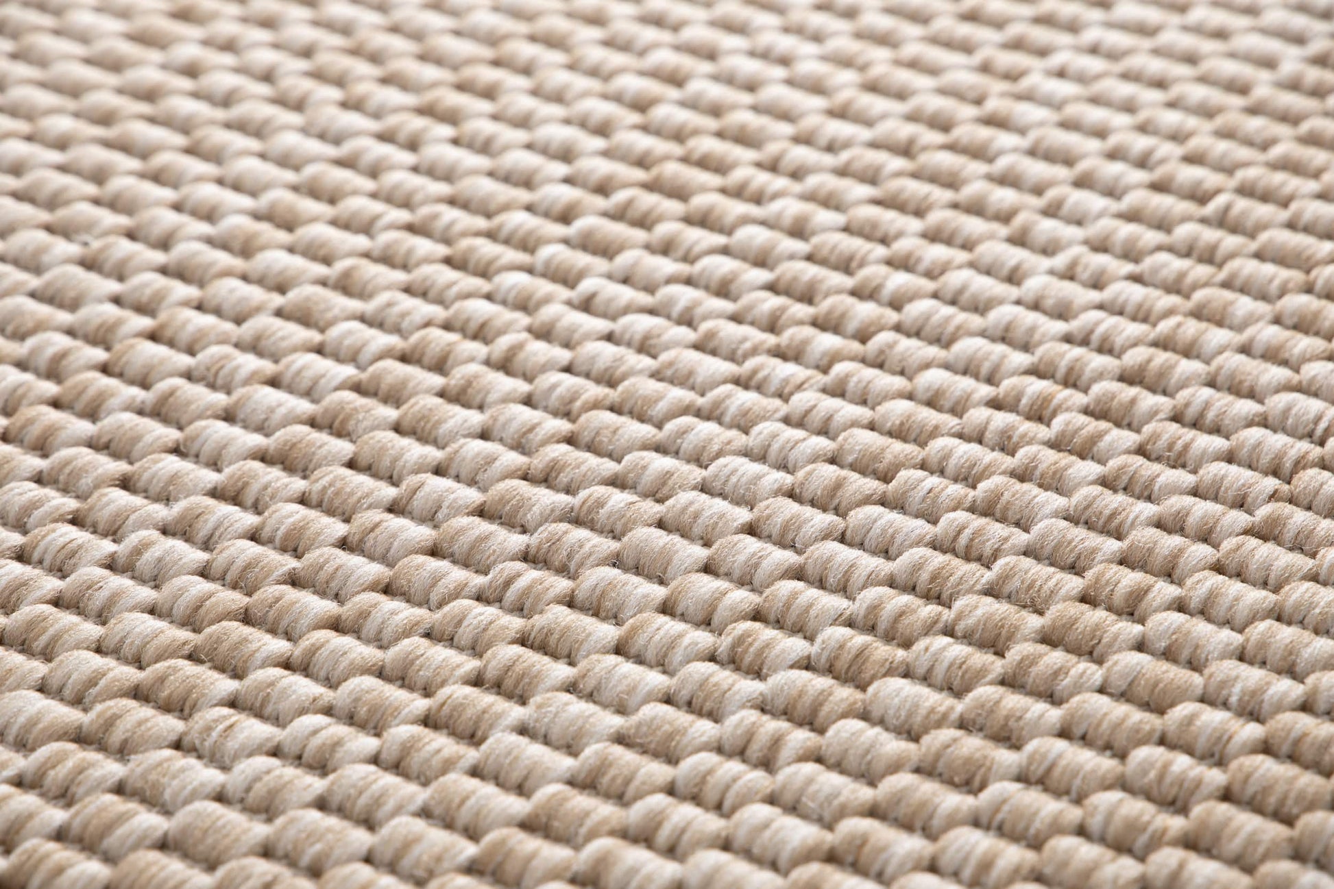 Tapis tissé à relief, texture bouclée. Aspect tactile doux, couleurs beige et ambre