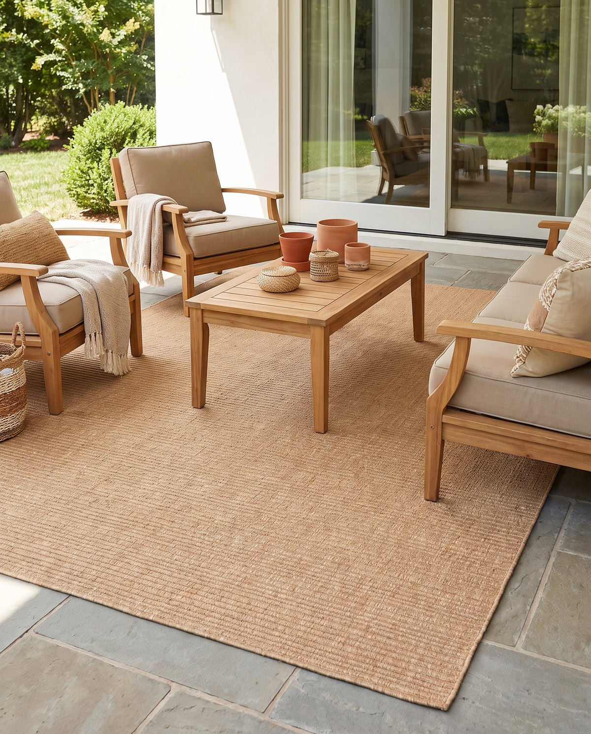 Sur une terrasse ensoleillée, un tapis d'extérieur rectangulaire terracotta clair affiche un tissage finement côtelé