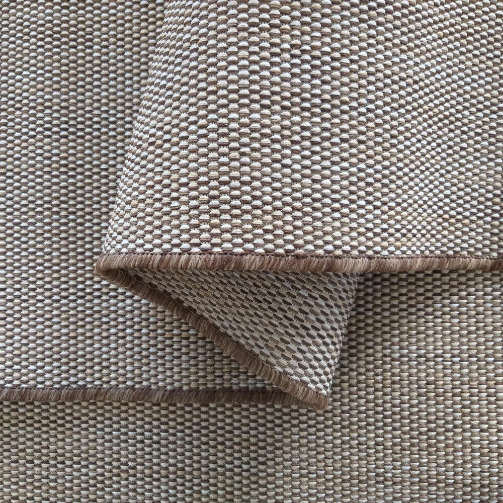 Tapis tissé à motif texturé, mélange de tons beige clair et brun, avec une bordure marron foncé visible sur une partie repliée