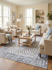 Grand tapis rectangulaire crème à motifs de carrés irréguliers bleus et gris texturés au centre d'un salon