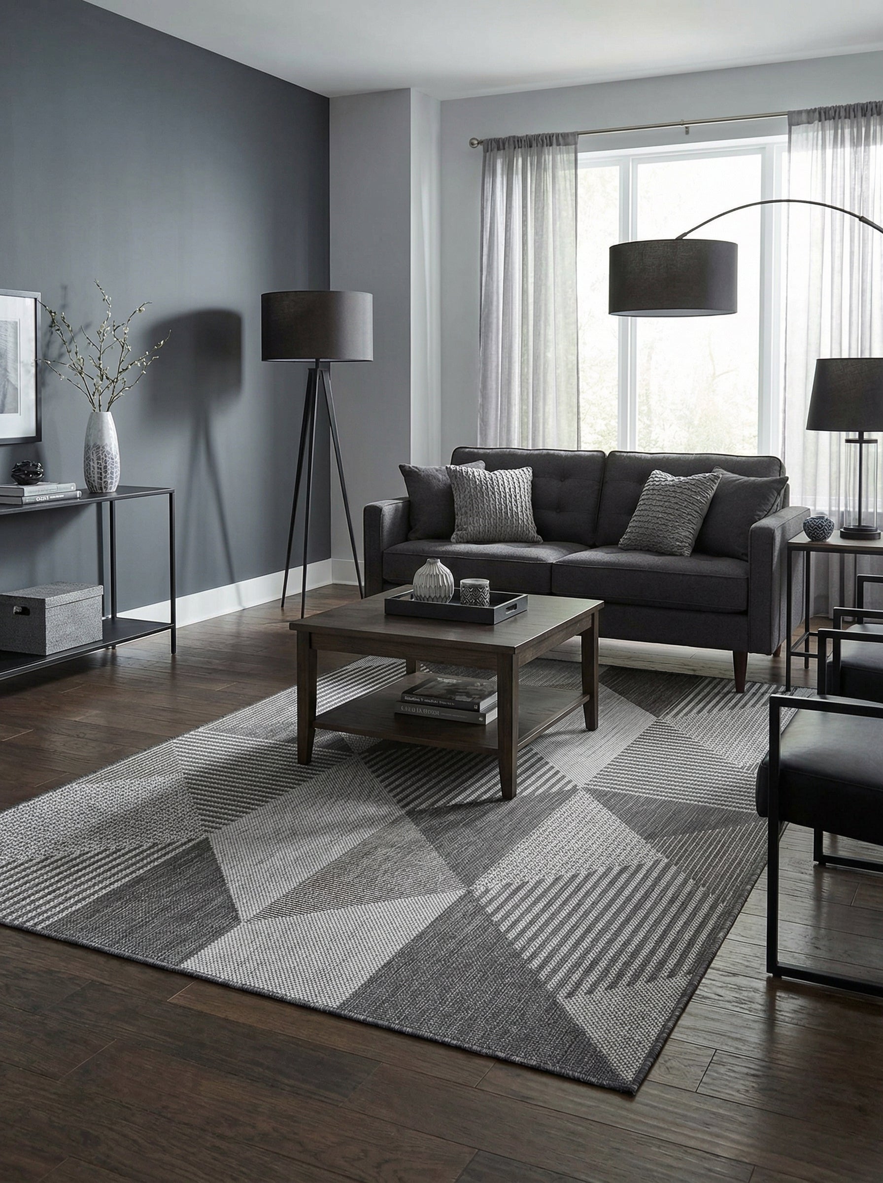 Tapis rectangulaire en tissage gris clair et foncé, avec des motifs géométriques et des rayures, posé sur un parquet dans un salon moderne