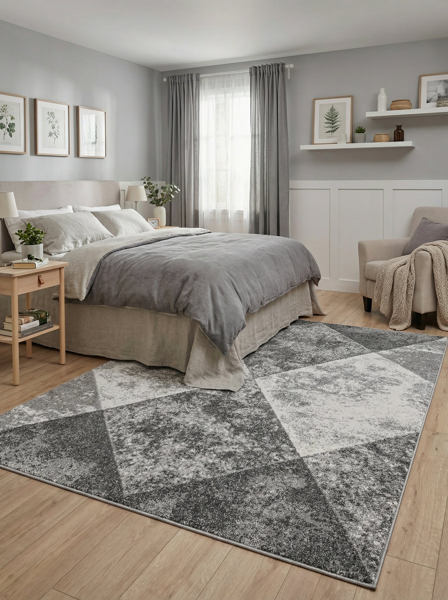 Tapis rectangulaire aux motifs géométriques gris foncé, gris clair et blanc texturé, posé sur le sol d'une chambre
