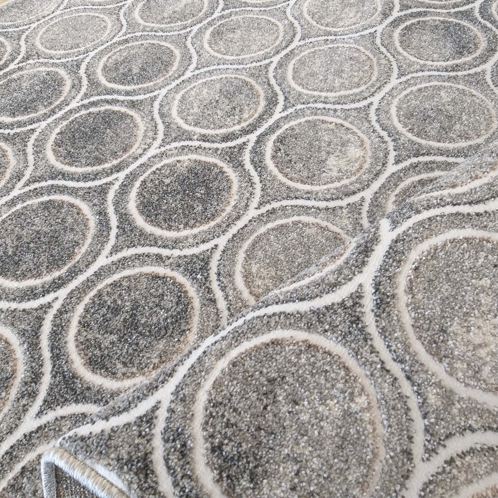 Tapis gris moucheté à la texture moelleuse présentant un motif de cercles entrelacés délimités par des lignes claires
