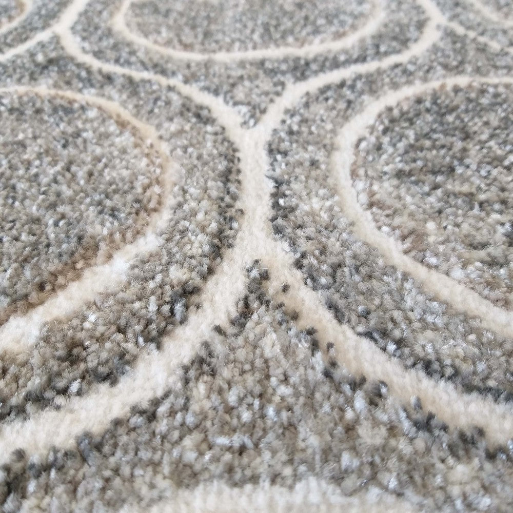 Tapis texturé gris et crème avec un motif abstrait de lignes courbes entrelacées, aspect moelleux