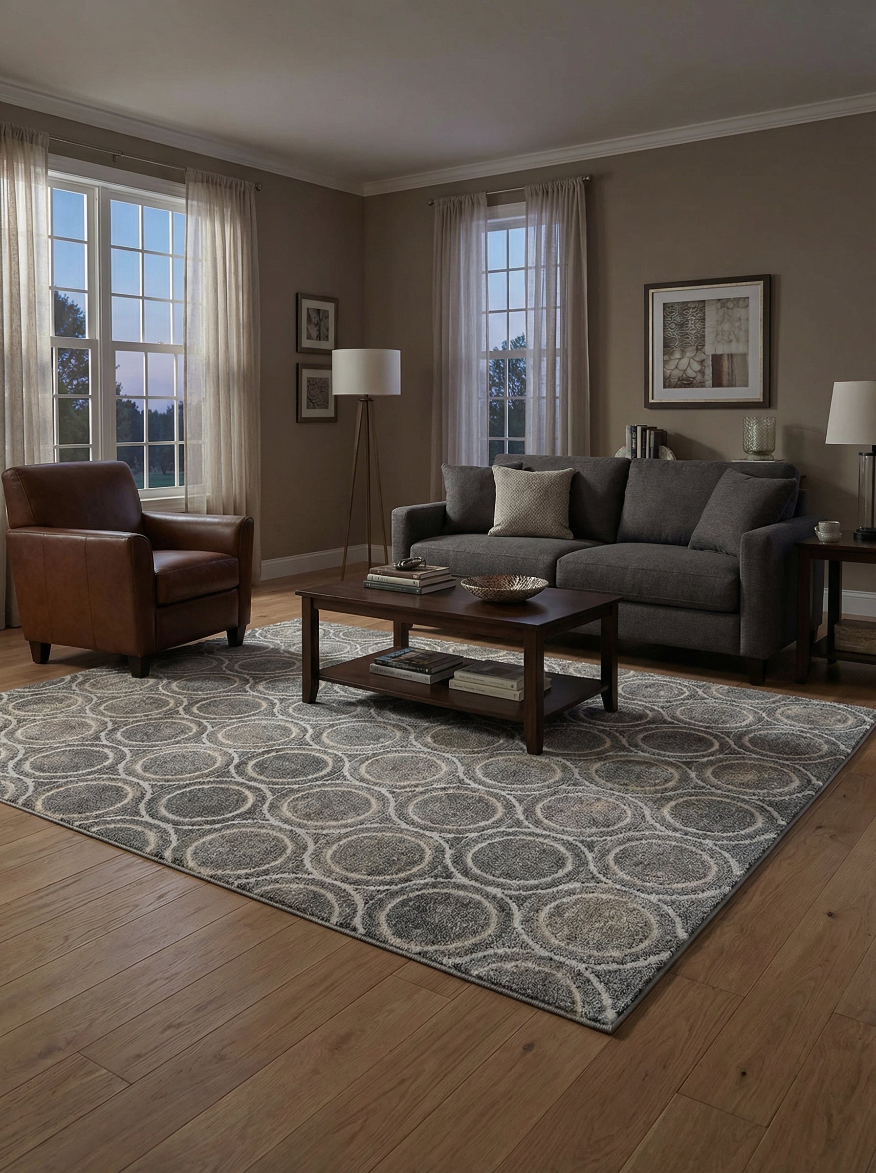 Grand tapis rectangulaire gris et beige aux motifs de cercles entrelacés texturés, posé sur un parquet dans un salon