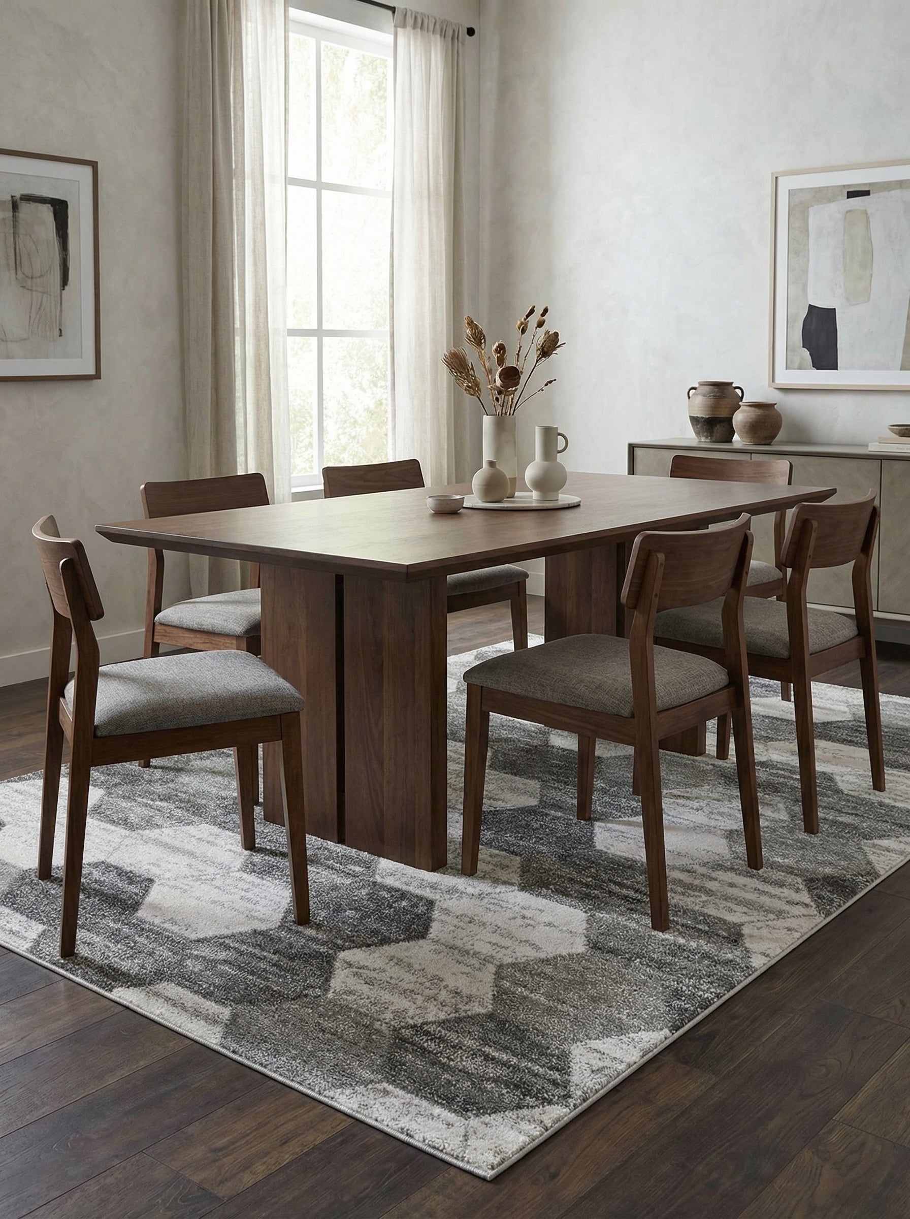 Tapis rectangulaire gris, blanc et noir aux motifs hexagonaux abstraits et chinés, dans une salle à manger