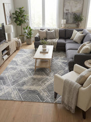 Grand tapis rectangulaire gris et crème avec motifs géométriques abstraits et lignes entrecroisées, au sol d'un salon