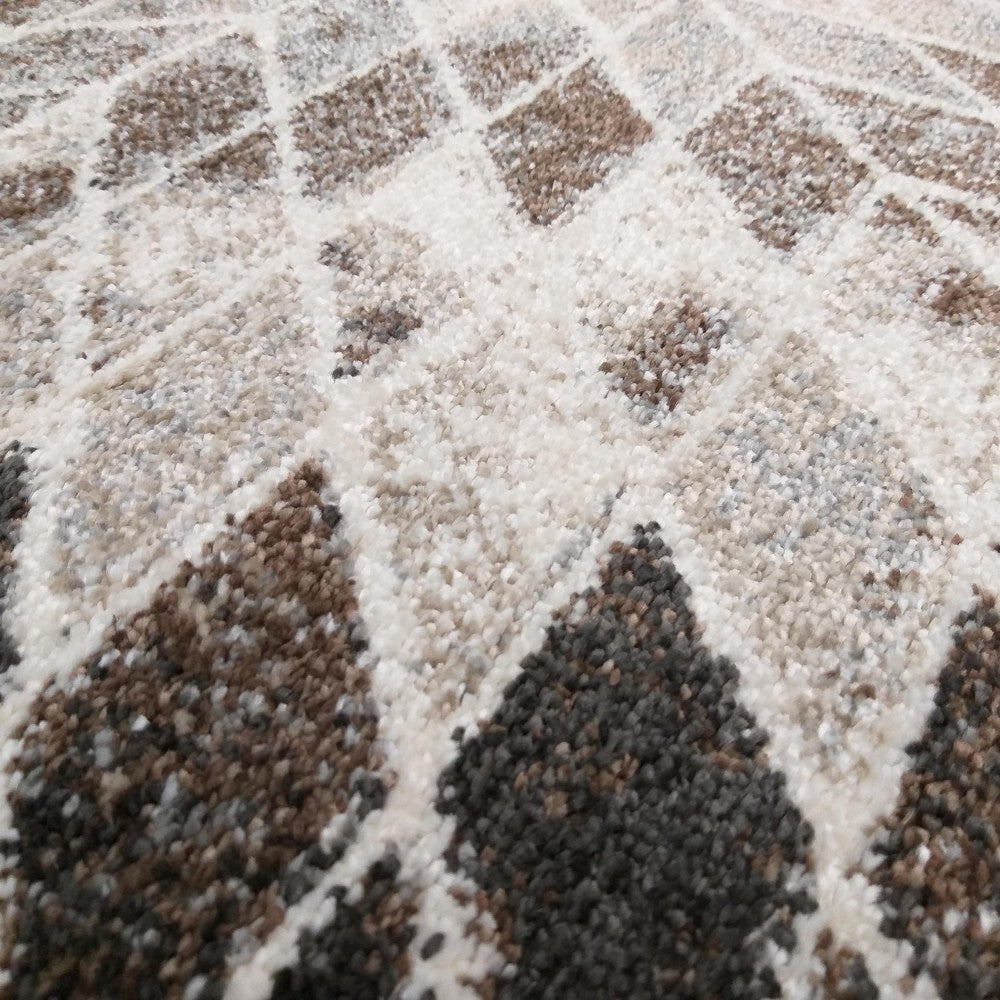 Tapis à motifs géométriques en losanges et triangles, dans des tons de crème, beige et marron foncé, à la texture chinée