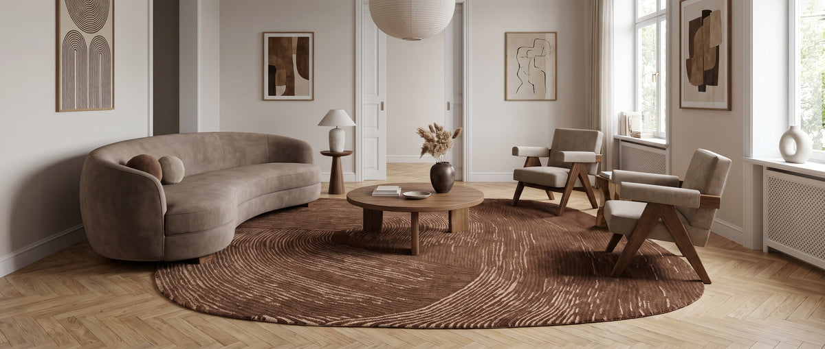 Des arabesques texturées brun chocolat et beige composent ce tapis ovale organique en laine et coton dans un salon épuré