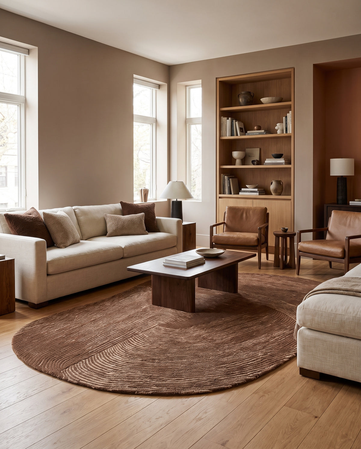 Ses motifs ondulés brun chocolat et beige animent ce tapis ovale organique en laine et coton, dans un salon
