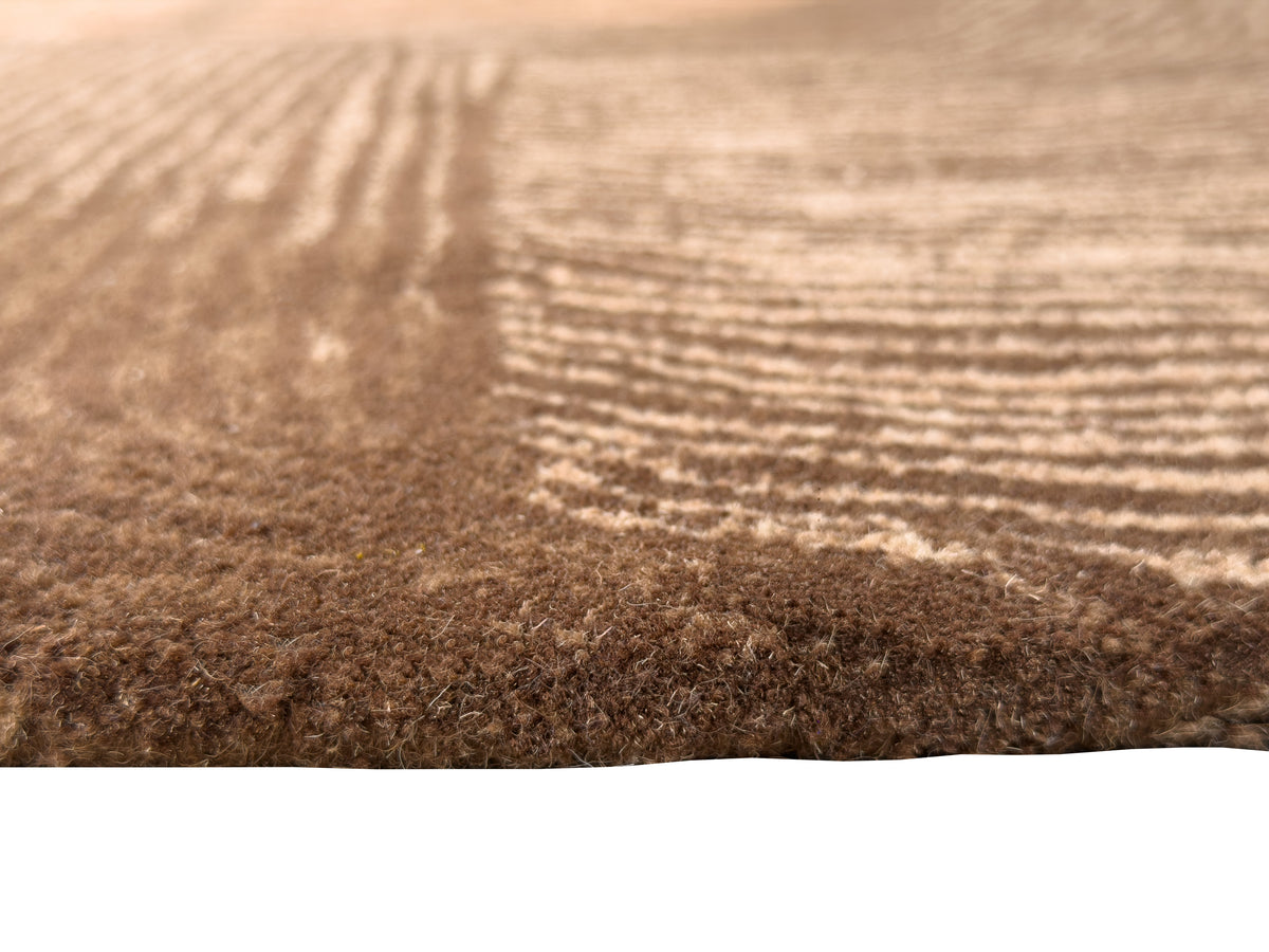 Les fibres denses en laine et coton du tapis fait main créent un relief ondulé brun chocolat et beige