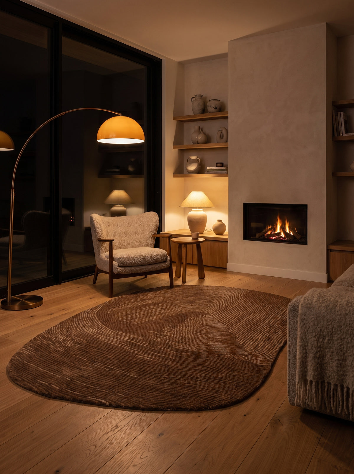 Des vagues brun chocolat et beige animent ce tapis ovale organique en laine et coton, posé dans un salon chaleureux
