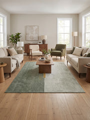 Laine et soie de bambou bouclées forment un tapis vert foncé et vert pâle coupé d'une bande ocre, au sol d'un salon