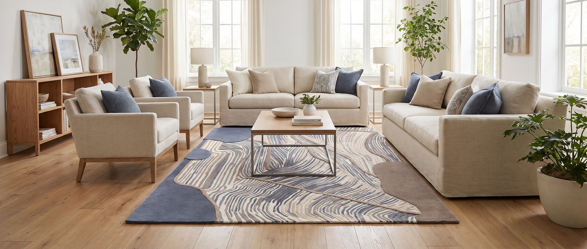 Motifs fluides abstraits en laine et viscose bleu acier, crème et brun animent ce tapis fait main dans un salon lumineux