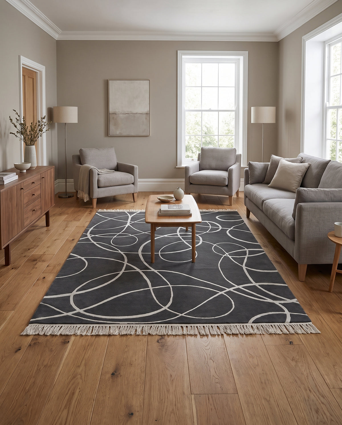 Tufté main, tapis gris anthracite laine et viscose, à courbes argentées sculptées et franges claires, dans un salon