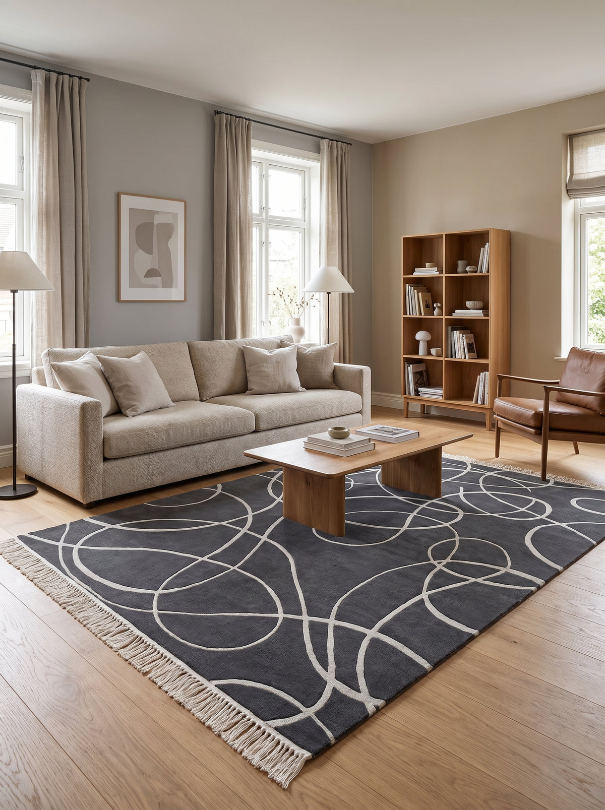 Laine et viscose gris anthracite : tapis tufté main aux courbes argentées sculptées et franges claires, dans un salon