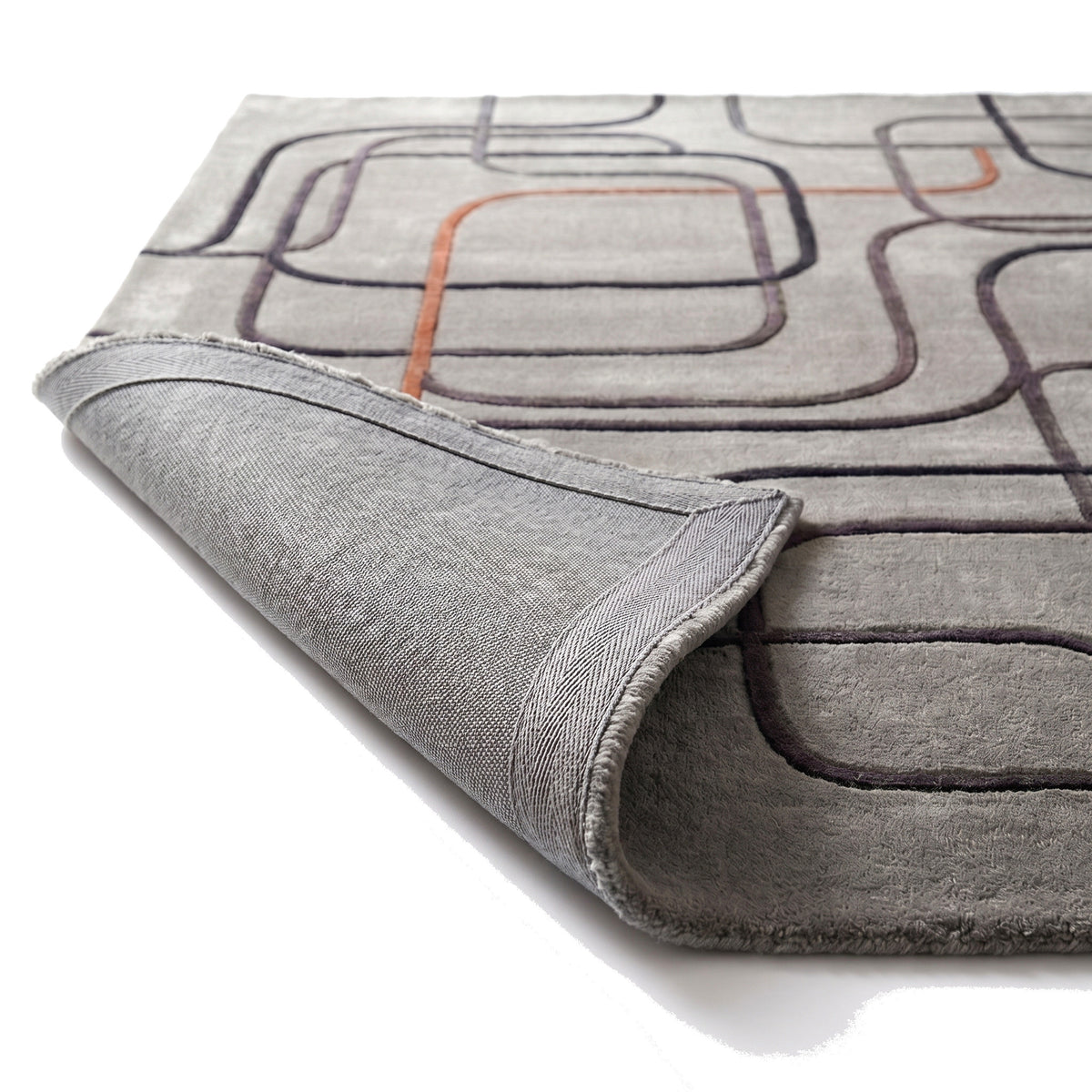 Le dos tissé, l'épaisseur et les motifs anthracite et cuivre en relief du tapis laine et viscose