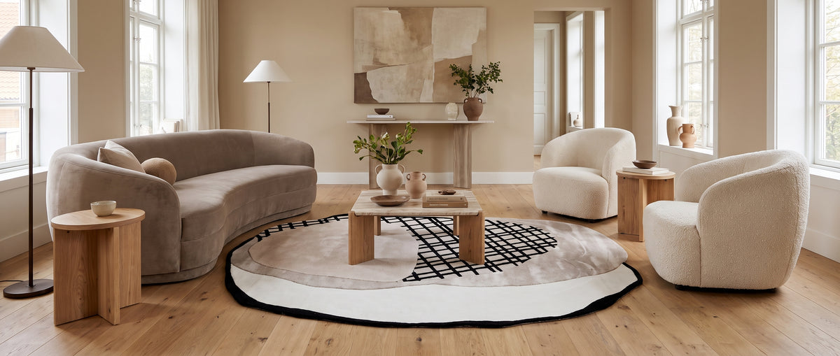 Organique, ce tapis en laine et viscose mêle velours gris, taupe et blanc cassé à un motif noir en bouclettes, en salon