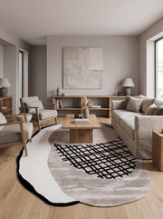 Ce tapis organique mêle velours rasé gris, taupe et blanc cassé à un motif de grille noire en bouclettes dans un salon