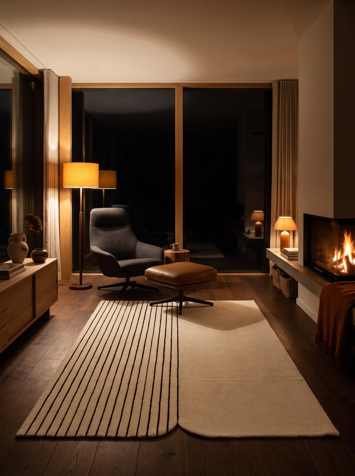 In this living room at night, an ivory and black wool and viscose rug features textured stripes and soft angles