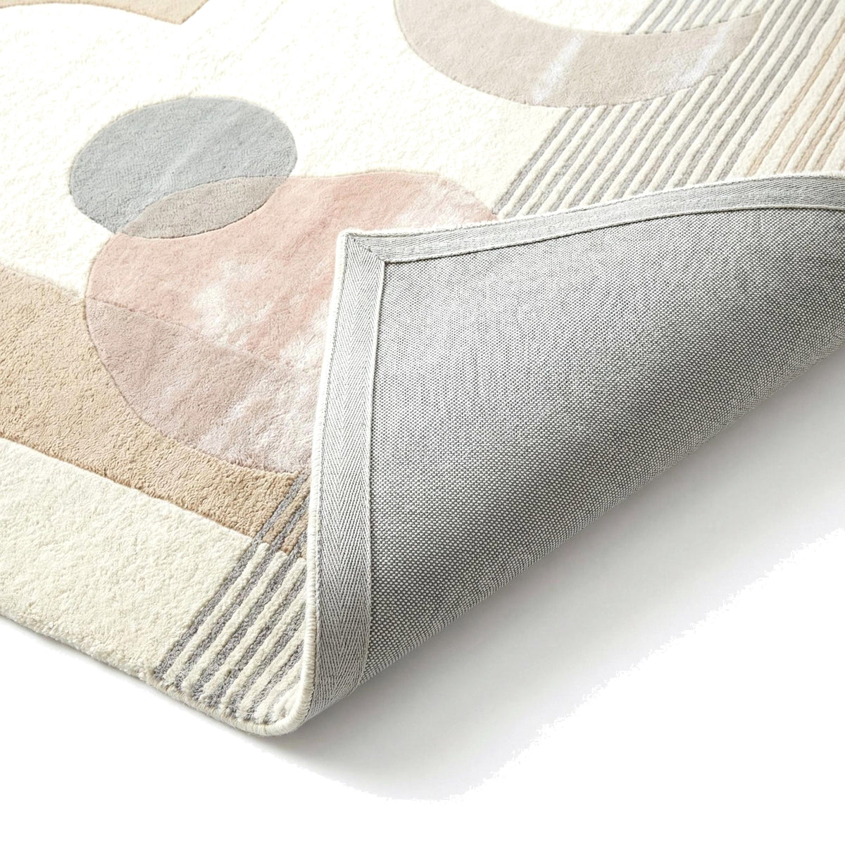 La texture riche du tapis laine et viscose ivoire aux motifs rose et gris et son dos tissé gris
