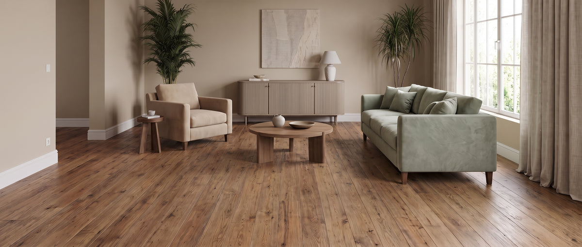 Grand salon moderne au parquet bois nu et sans tapis, avec un canapé vert pâle, un fauteuil beige, un buffet et des plantes