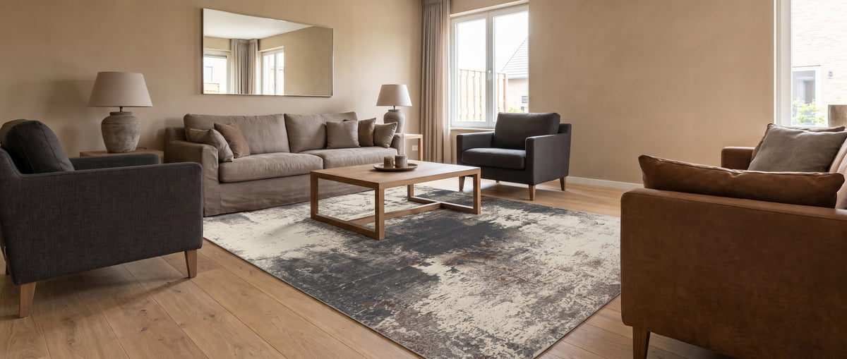 Affichant un motif abstrait texturé en bleu ardoise, brun et crème, ce tapis lavable rectangulaire décore un salon