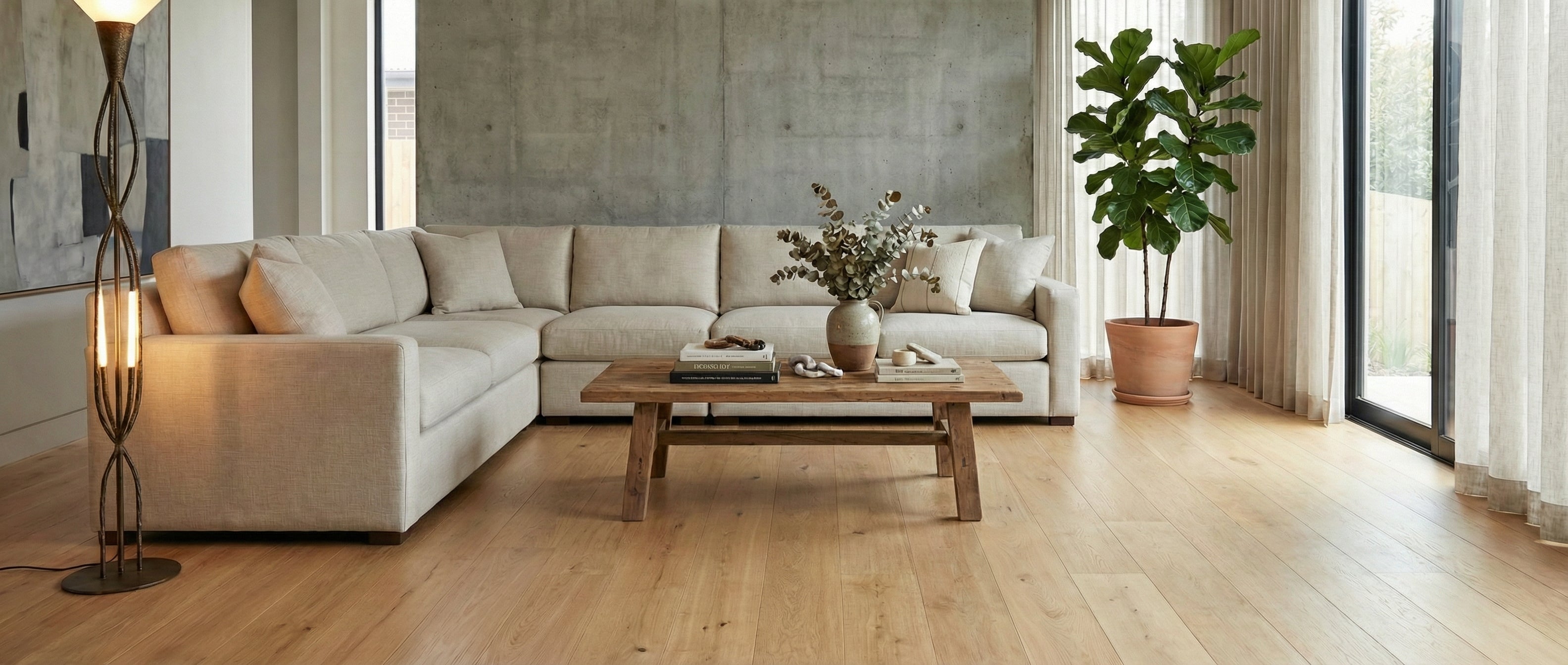 Pièce lumineuse, canapé clair, mur béton, parquet clair. Espace vide pour un tapis rectangulaire, ambiance neutre