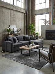 Tapis gris rectangulaire dans un salon. Crée une ambiance feutrée, s'harmonise avec le décor industriel