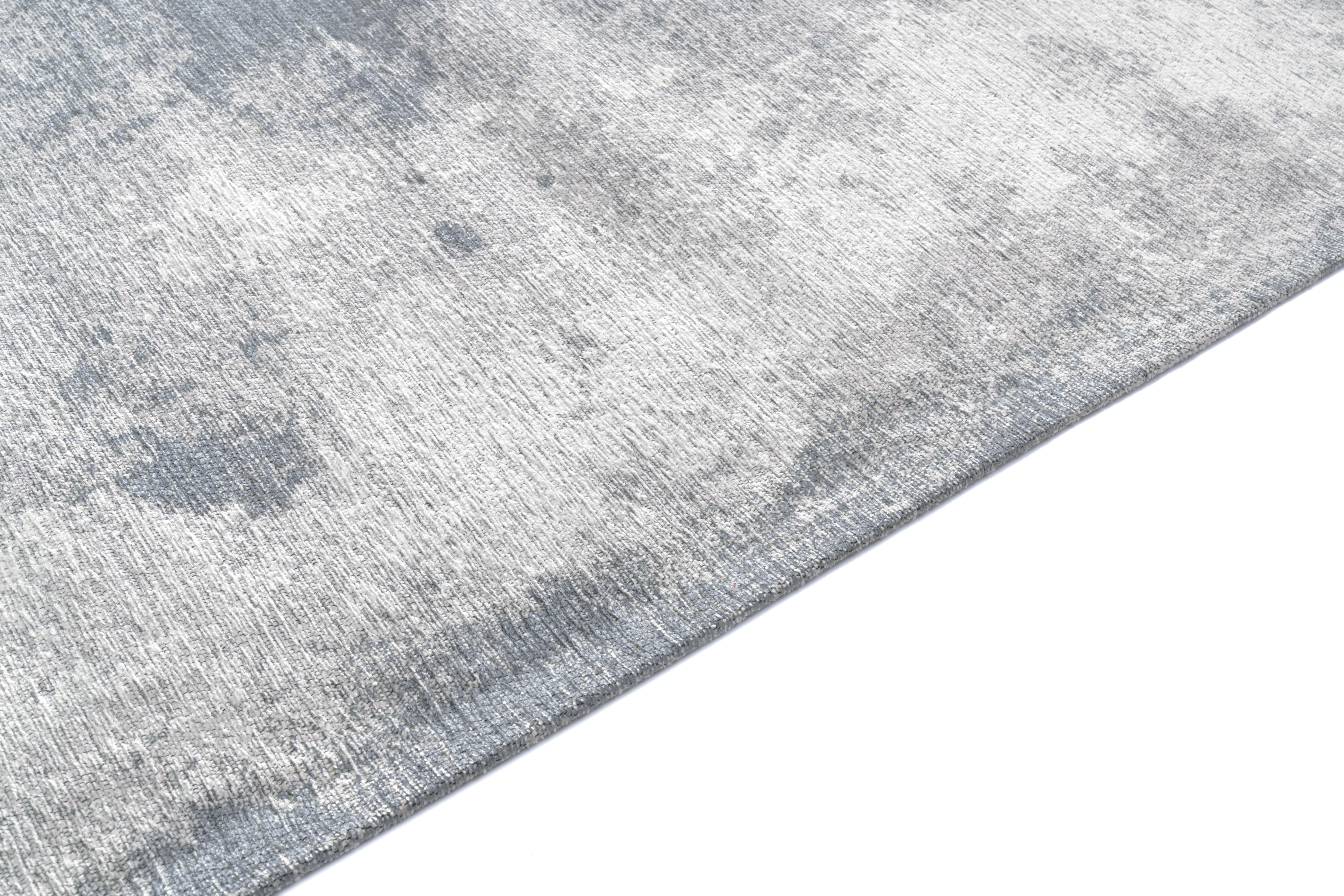 Tapis rectangulaire gris. Tissage texturé avec relief. Aspect tactile doux et irrégulier