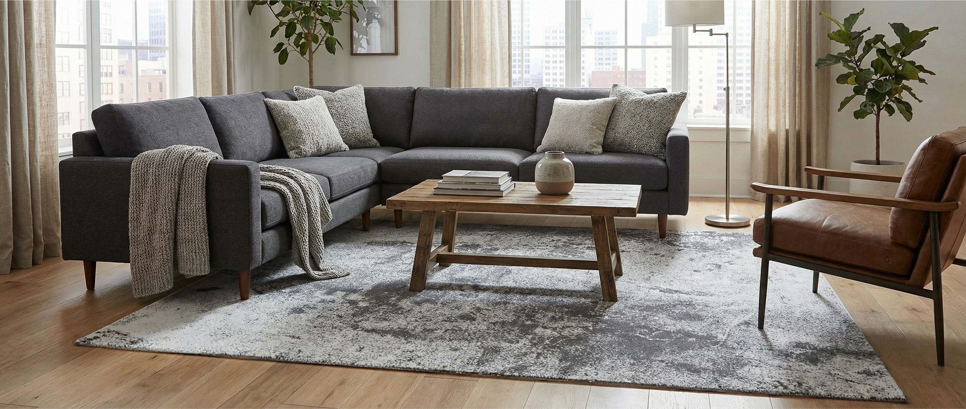 Un tapis rectangulaire gris crée une harmonie dans la pièce. La transformation est subtile, l'ambiance est chaleureuse