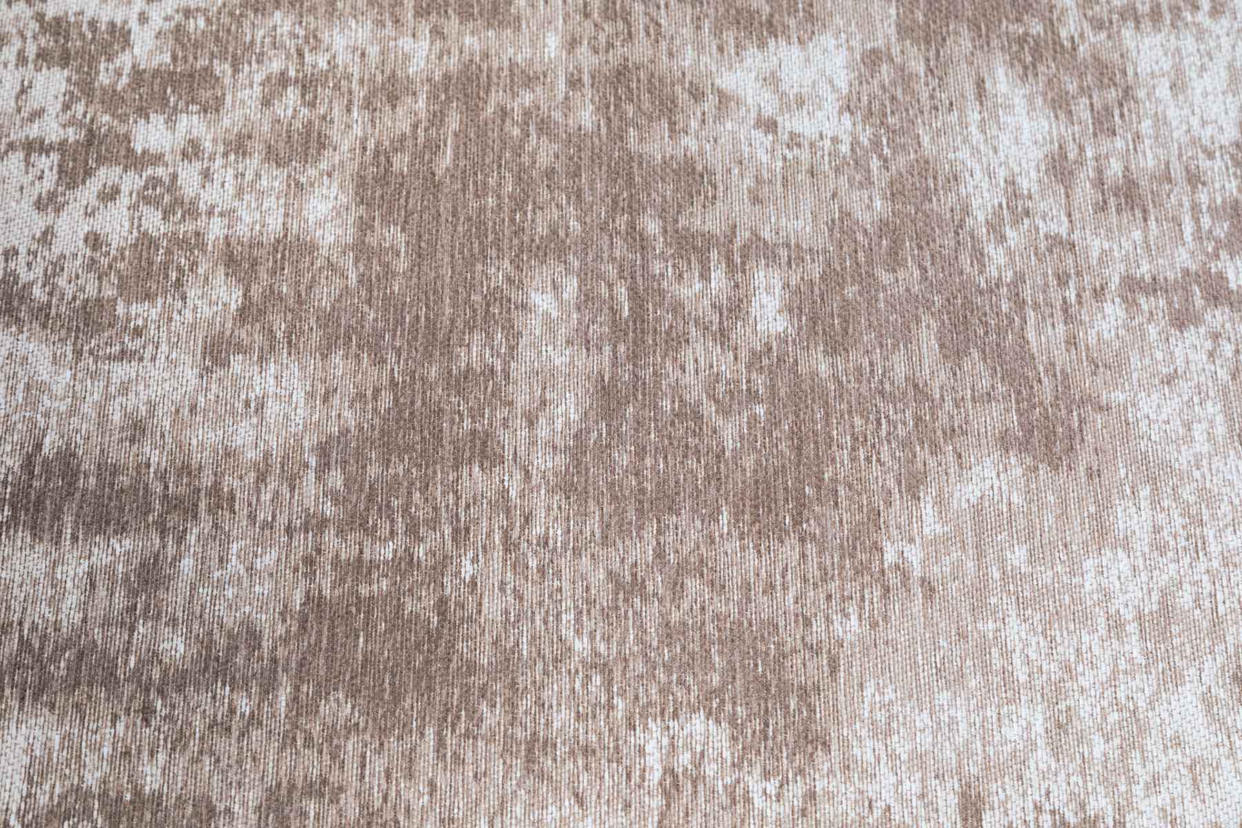 Gros plan sur un tapis lavable Miro avec un motif abstrait taupe et une texture en fibres pour une ambiance chaleureuse.