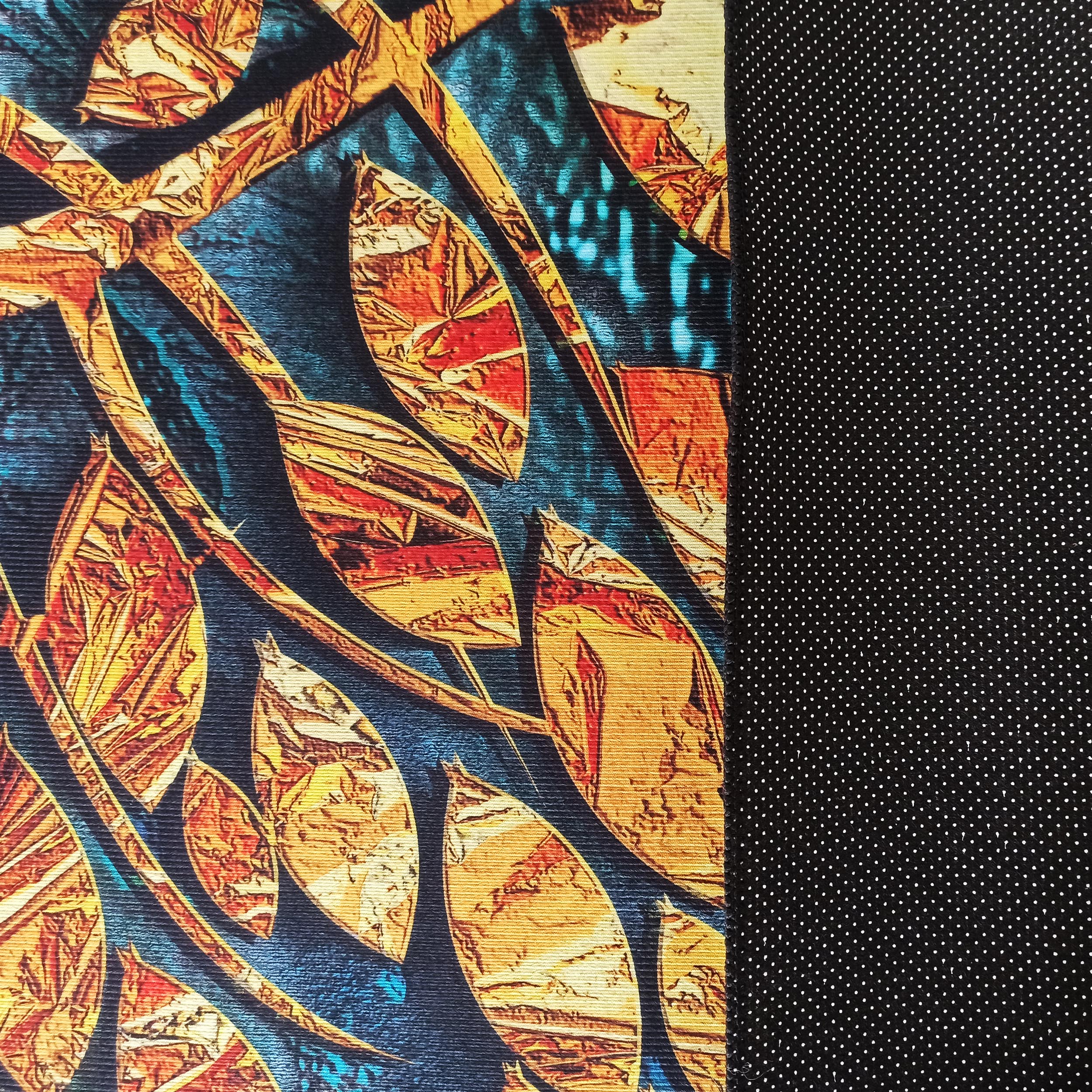 Tapis texturé avec des feuilles stylisées orange, jaune et rouge sur fond bleu-vert, et une face arrière noire à pois blancs