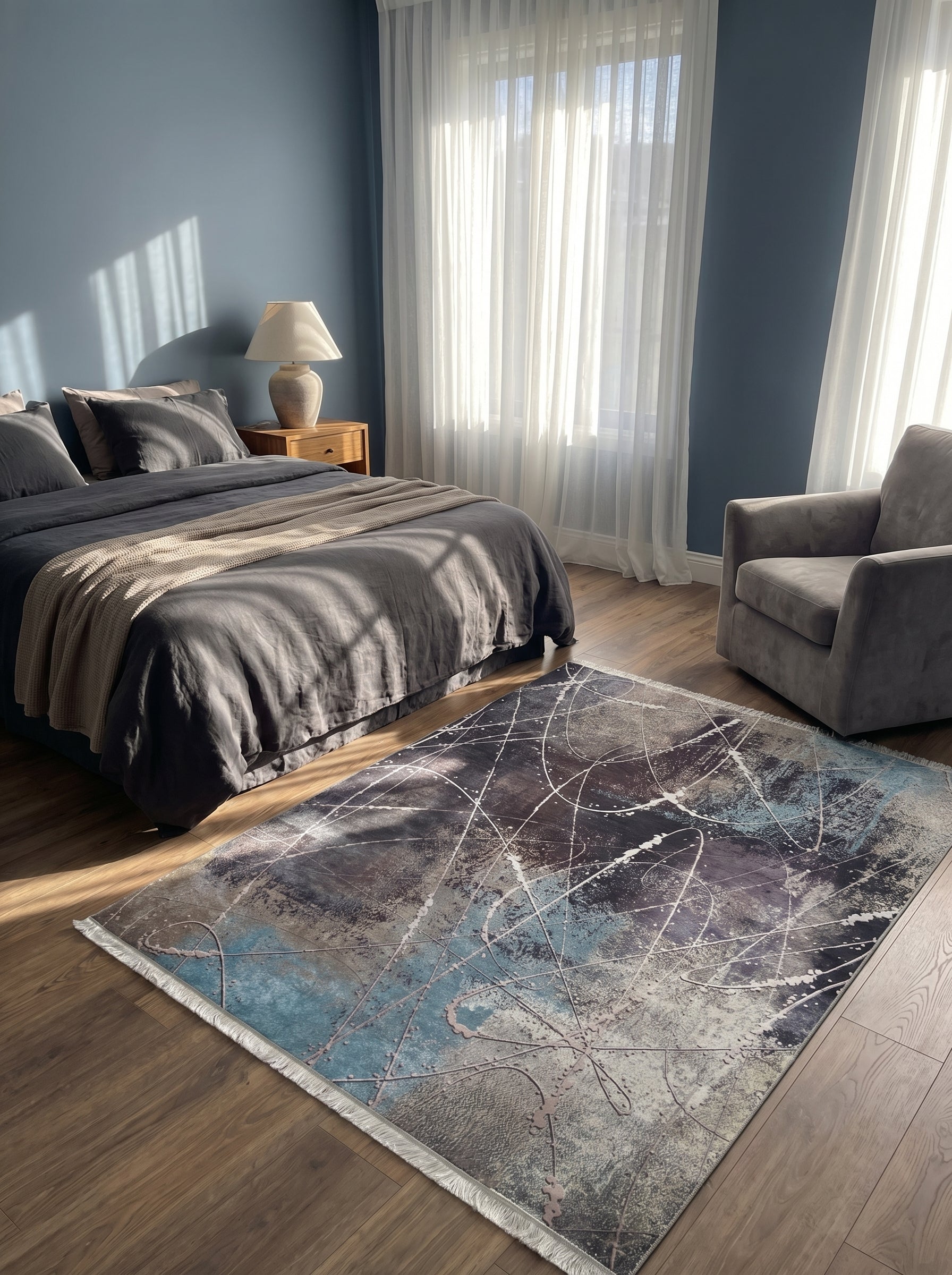 Tapis rectangulaire abstrait aux motifs bleus, gris, marrons et lignes blanches, à franges, sur parquet dans une chambre