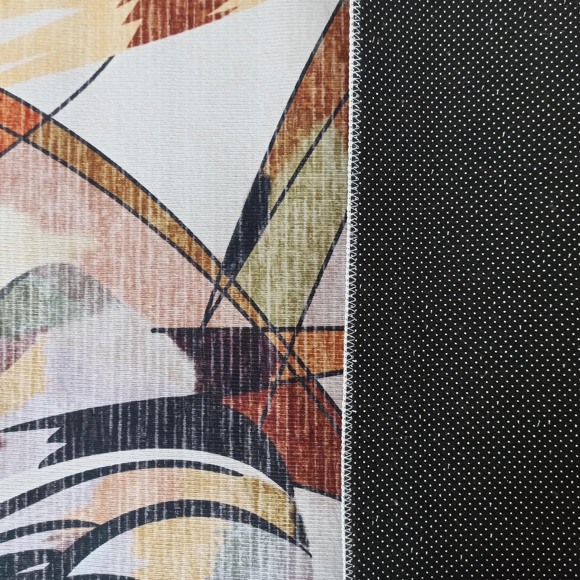 Tapis avec un côté supérieur aux motifs abstraits géométriques multicolores et un dessous noir antidérapant à pois blancs