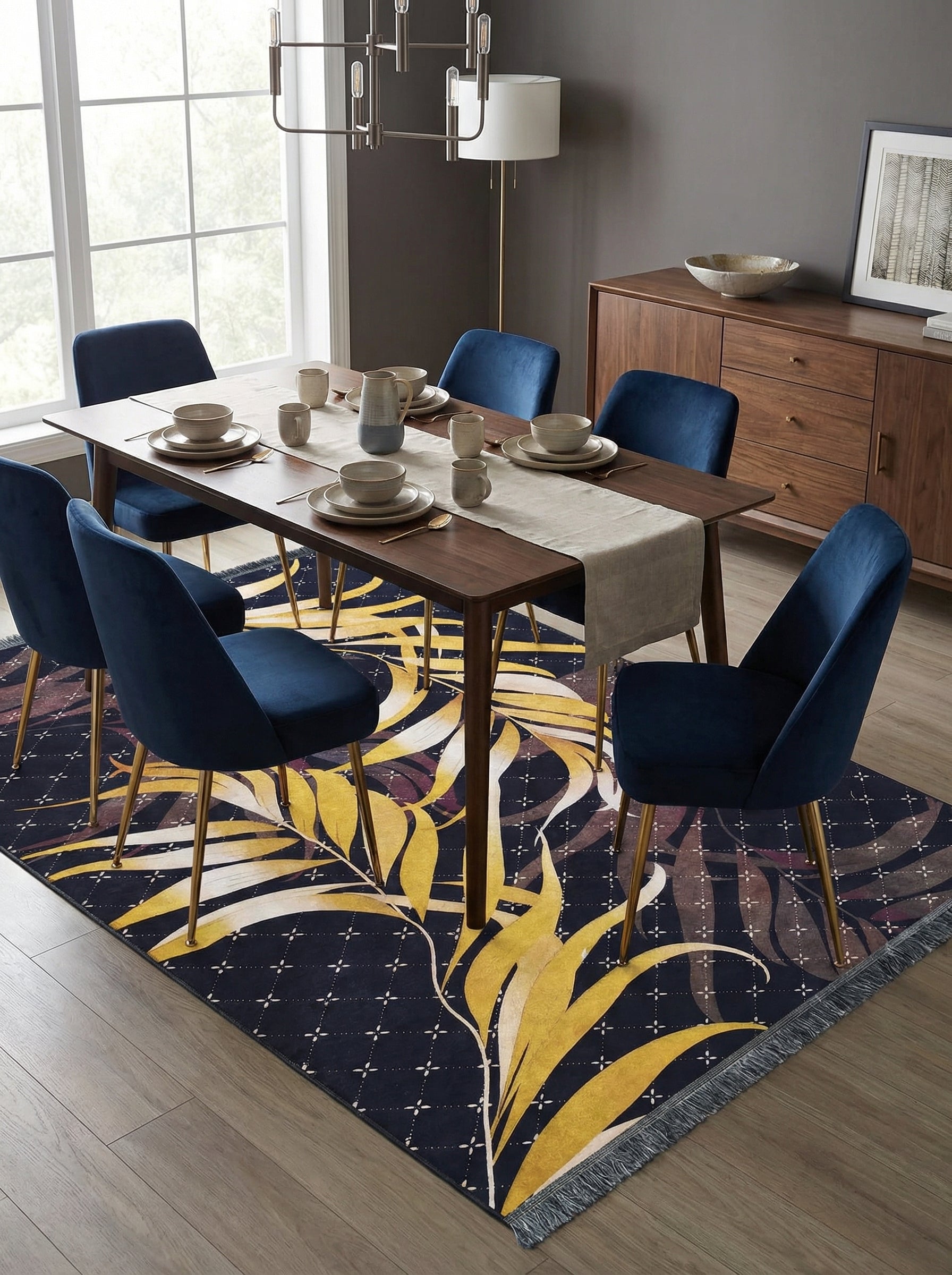 Tapis rectangulaire bleu marine à grandes feuilles tropicales jaunes, marron et crème, avec franges, sous une table de salle à manger