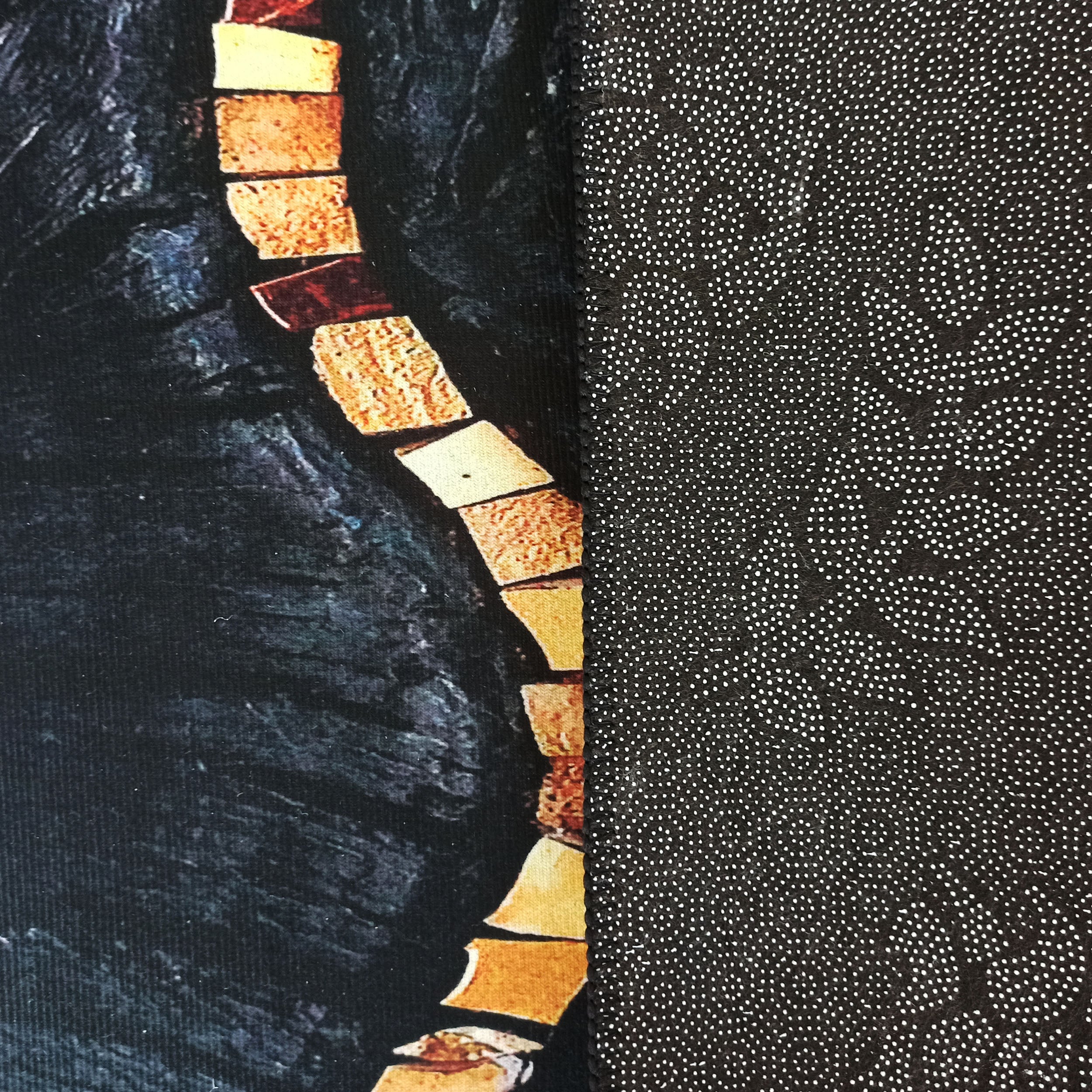 Tapis avec un côté gauche foncé et marbré orné d'une ligne de fragments aux tons terreux, et un côté droit noir à pois blancs