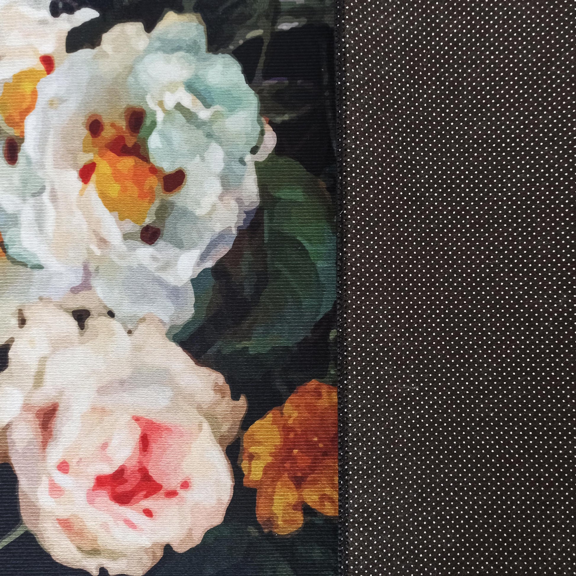 Tapis à double motif. Côté gauche floral avec grandes fleurs claires sur fond sombre. Côté droit noir à petits pois blancs