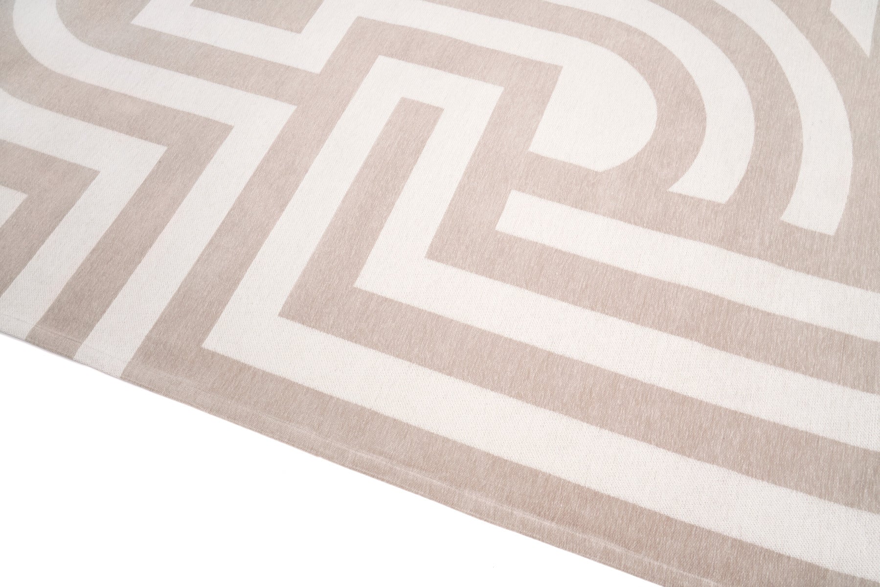 Gros plan sur la texture d'un tapis géométrique beige Lavable Vendome avec des motifs de lignes et de courbes entrelacées, offrant un style moderne.