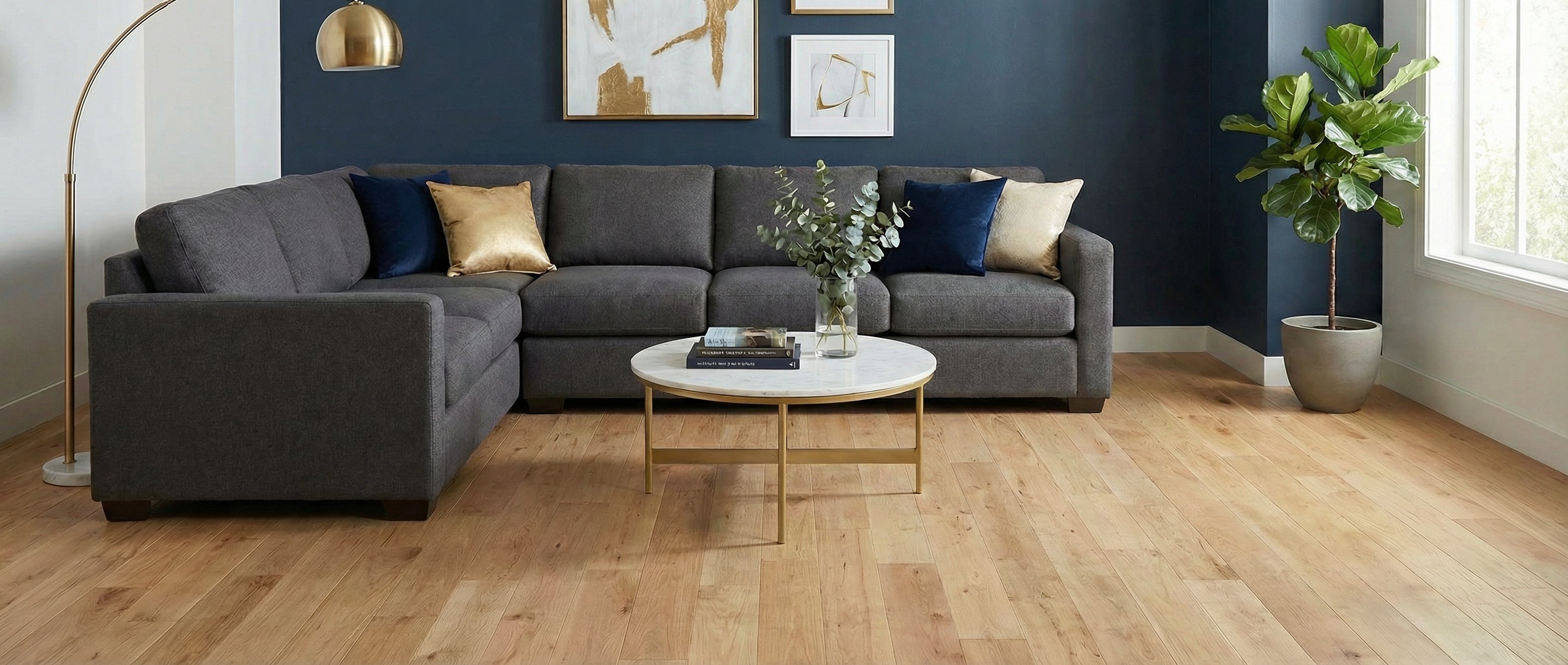 Pièce lumineuse avec parquet clair, canapé gris, coussins colorés, mur bleu. Potentiel déco: tapis rond, ambiance chaleureuse