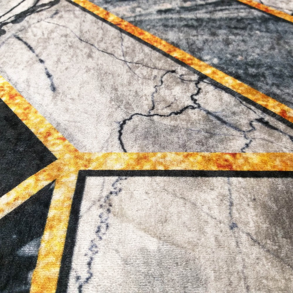 Tapis en velours gris et noir, avec des motifs de marbre et des bandes géométriques dorées