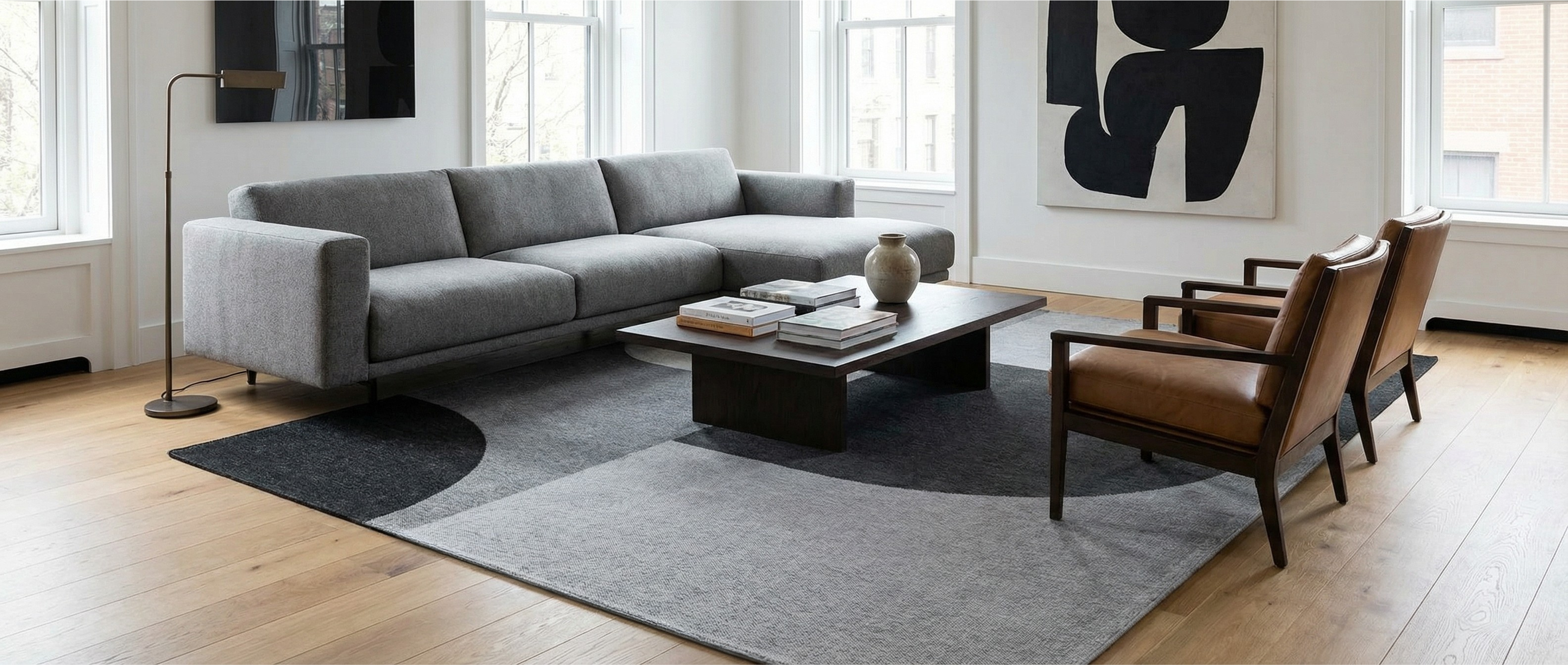 Le tapis rectangulaire gris crée une harmonie. Il transforme la pièce en ajoutant une ambiance moderne et chaleureuse