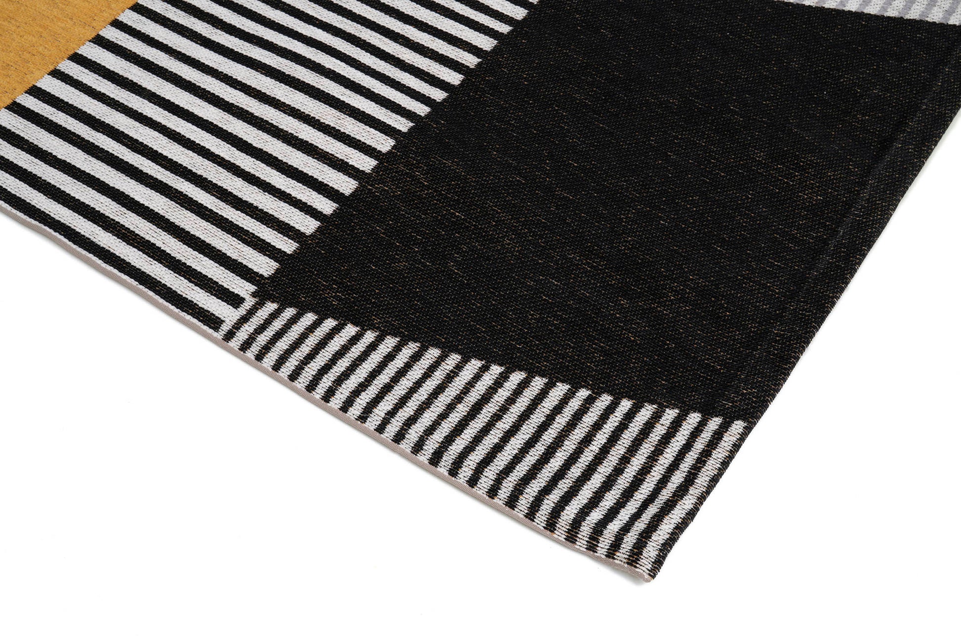 Bordure de tapis à rayures noires et blanches. Finition de qualité, ambiance moderne. Forme rectangulaire, couleurs neutres